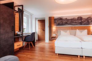 派尔巴赫Hotel Payerbacherhof的卧室配有白色的床和书桌