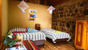 圣胡安拉拉古纳玛雅奇客环保酒店的石墙客房的两张床