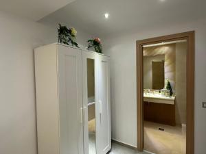 布加勒斯特Cherry Apartment的浴室设有白色的橱柜,上面有鲜花