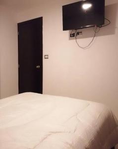 危地马拉Apartamento zona 4 Guatemala y Parqueo的卧室配有一张床,墙上配有电视
