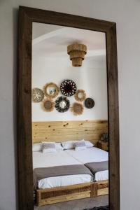 塔姆拉赫特乌兹达尔MAKTUB SURF HOUSE的镜子反射着一间卧室,配有两张床和装饰