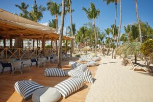 蓬塔卡纳Bahia Principe Luxury Esmeralda All Inclusive - Newly Renovated的海滩上的一排躺椅和遮阳伞