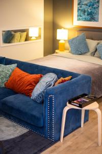 洛杉矶Luxury Apartment In The Prime Hollywood Location的客厅配有蓝色的沙发和床。