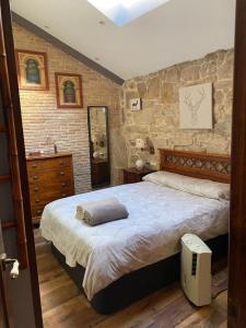 巴约讷Casa Celsa cerca del mar的一间卧室设有一张大床和石墙