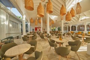 蓬塔卡纳Bahia Principe Luxury Esmeralda All Inclusive - Newly Renovated的一间带桌椅和灯光的餐厅