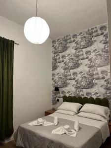 罗马装饰艺术酒店的一间卧室设有一张大床和大墙