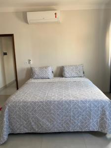 索里苏Apartamento Sorriso的一张带蓝色棉被和两个枕头的床