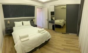 伊斯坦布尔OSMANBEY DUPLEX Apartment 3的卧室配有一张白色大床和镜子