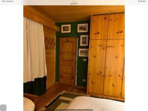 卡瓦莱塞Baita cavalese giardino esclusivo的一间卧室设有木墙、一张床和一扇门