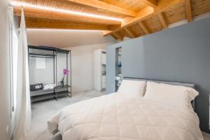 福尔米吉内Borgo degli Ulivi的卧室配有白色的床和镜子