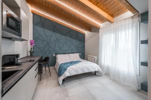 福尔米吉内Borgo degli Ulivi的一间卧室设有一张大床和大窗户