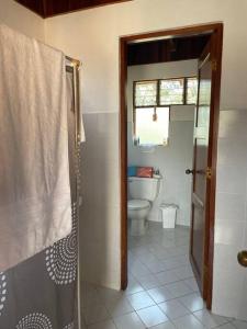 普拉亚埃尔莫萨Villa Hermosa的一间带卫生间和玻璃淋浴间的浴室