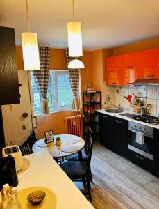 布加勒斯特Euro Apartment的厨房配有橙色橱柜和桌椅