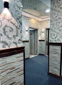 安曼拜尔克尼酒店的一间设有走廊、壁纸墙的房间