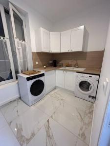 德勒Golden House的厨房配有白色橱柜、洗衣机和烘干机