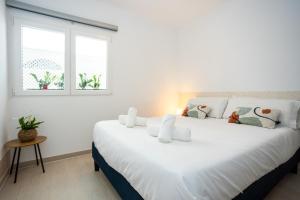 卡拉德莫尔Naim Playa的配有2扇窗户的客房内一张大白床