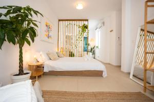 卡拉德莫尔Naim Playa的一间卧室配有一张床和盆栽植物