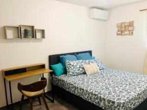 莱特鲁瓦西莱Appartement neuf 4/6 personnes, près de la plage的一间卧室配有一张带蓝色枕头的床和一把椅子