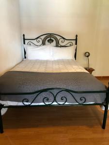 Casa BrancaCasa d'Aldeia的一张带黑色金属框架和白色枕头的床