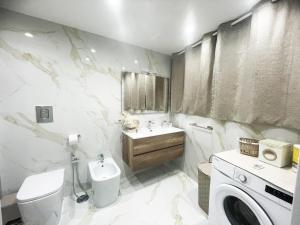 波蒂奇Casa Vacanze Riccardi的浴室配有卫生间、盥洗盆和洗衣机。