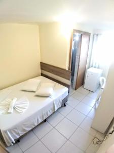 马蒂尼奥斯Hotel Praia e Sol的一间卧室配有带白色床单和枕头的床。