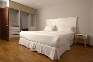 昆卡Santa Lucia Suites - Barranco的卧室配有一张带白色床单和枕头的大床。