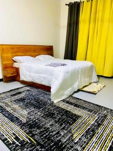 坦噶Drew Apartment Tanga的卧室配有一张铺在地板上的地毯。