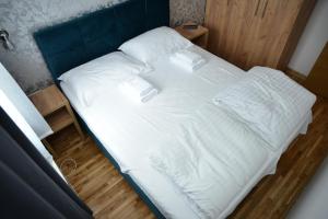 科帕奥尼克Kraljevi Cardaci Cardak的一张配有白色床单和枕头的大床