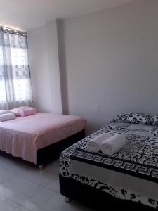 曼克拉Hospedaje EL MARQUEZ Expat的一间卧室设有两张床和窗户。