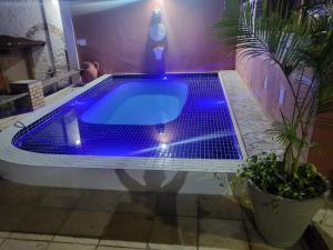 纳塔尔Pousada Saruê Natal Praia RN的浴室内配有蓝色灯光浴缸。