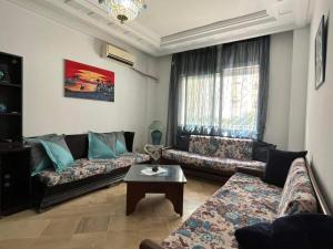 El AouinaJARDIN Apartments的客厅配有两张沙发和一张咖啡桌