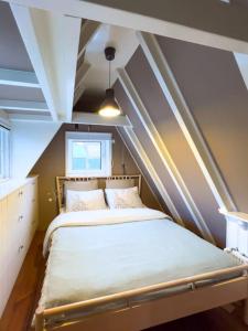 滨海韦克Fisherman's Cottage - Surf Retreat的一间小卧室,阁楼上配有一张床