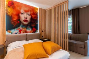 多索博诺La Pergola Suites的一间装饰有红发女人画的卧室