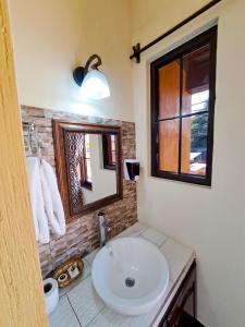 雷塔卢莱乌La Mansión del Gran Jaguar的浴室设有白色水槽和镜子