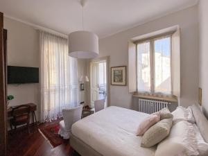 都灵L'Angolo di Casa Verrua的卧室设有白色的床和大窗户