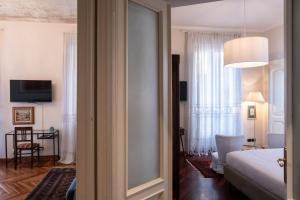 都灵L'Angolo di Casa Verrua的客房设有带一张床和镜子的卧室
