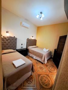 雷塔卢莱乌La Mansión del Gran Jaguar的酒店客房设有两张床和电视。
