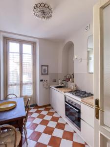 都灵L'Angolo di Casa Verrua的厨房配有桌子和炉灶。 顶部烤箱