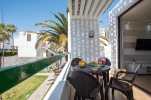 美洲海滩Precioso apartamento en el centro de Las Américas a 100 metros de la playa的阳台配有桌椅和电视。