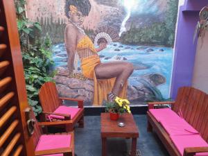 科尔多瓦Elisa Posada Hotel的一间设有椅子和女人壁画的房间