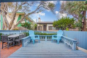 圣地亚哥Ormond Beach Oasis - Large Private Patio, WasherDryer, Pet Friendly & Steps2Sand!的庭院设有3个蓝色长椅和桌子