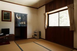 SuginosawaPension FOLKLORE的一个空房间,有窗户和电视