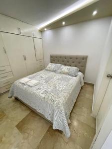 Catia La MarComodo Apartamento frente al Aeropuerto Maiquetia的一间小卧室,配有一张床和白色橱柜