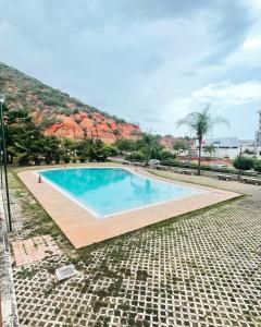 Catia La MarComodo Apartamento frente al Aeropuerto Maiquetia的一座大游泳池,后面是一座山