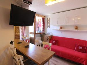 于埃Appartement Huez, 2 pièces, 5 personnes - FR-1-405-341的客厅配有红色的沙发和木桌