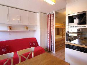 于埃Appartement Huez, 2 pièces, 5 personnes - FR-1-405-341的一间小厨房,在房间内配有红色沙发