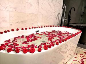 吉隆坡The Platinum Suites KLCC的浴室里装满红玫瑰的浴缸