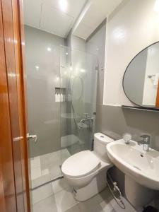 杜马格特Koze Suites的一间带卫生间、水槽和镜子的浴室