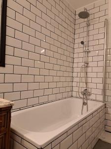 马德里Chueca Modern Apartment的浴室铺有白色瓷砖,配有浴缸。