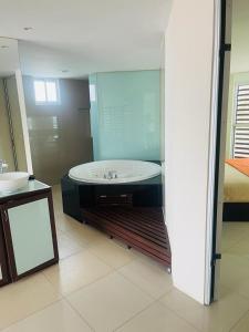 夸察夸尔科斯Hotel Torres Eugenia的一间带浴缸和大镜子的浴室
